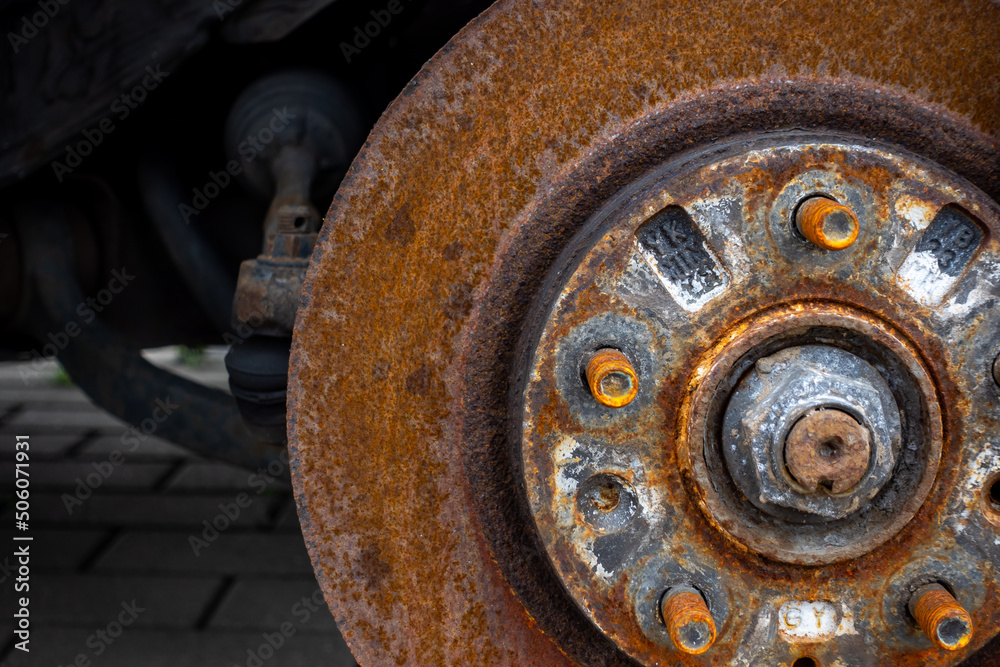 Rusty discs brake on an abandoned car. Object illuminated with soft, natural light Rusty discs brake on an abandoned car. Object illuminated with soft, natural light
