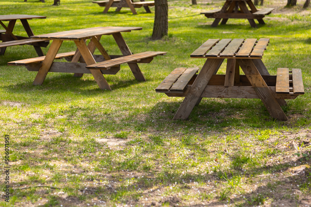 Tables and benches on the camping site. Photo taken on a sunny day. Objects in a shaded place