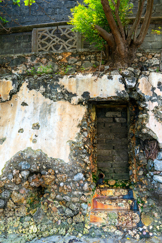 Fototapeta Naklejka Na Ścianę i Meble -  weathered wall with plaster and exposed rock coral stonework