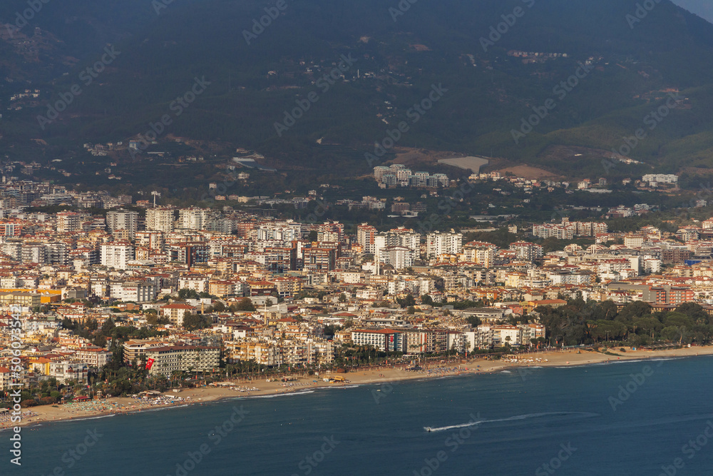 Turkey, Alanya, 30.08.2021: The city of Alanya (Turkey) and the Mediterranean Sea from a bird's eye view. Densely populated city and mountains from above. Travel to Turkey.