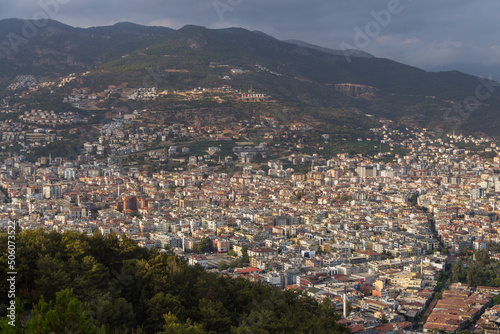 Turkey, Alanya, 30.08.2021: The city of Alanya (Turkey) from a bird's eye view. In the distance you can see an observation deck with the inscription "I love Alanya". Densely populated city from above.