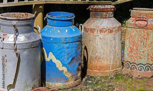 Old painted milk urns in a row. © Ellie