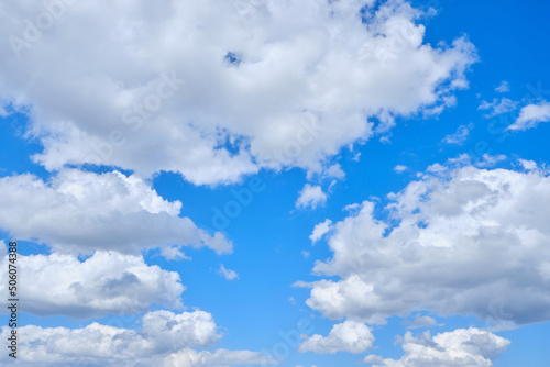 Background cumulus clouds against a blue sky illuminated by sunlight.