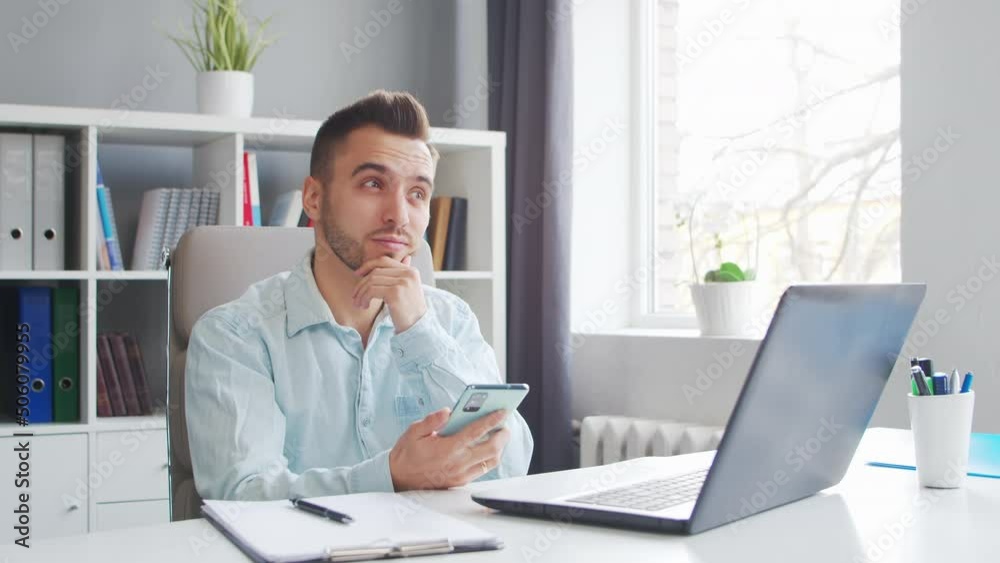 Young Man Works while Sitting in front of a Computer at Home. The Workplace of a Professional Worker, Freelancer or Student. Distance Work and Education Concept. Young Man Works while Sitting in front of a Computer at Home. The Workplace of a Professional Worker, Freelancer or Student. Distance Work and Education Concept.