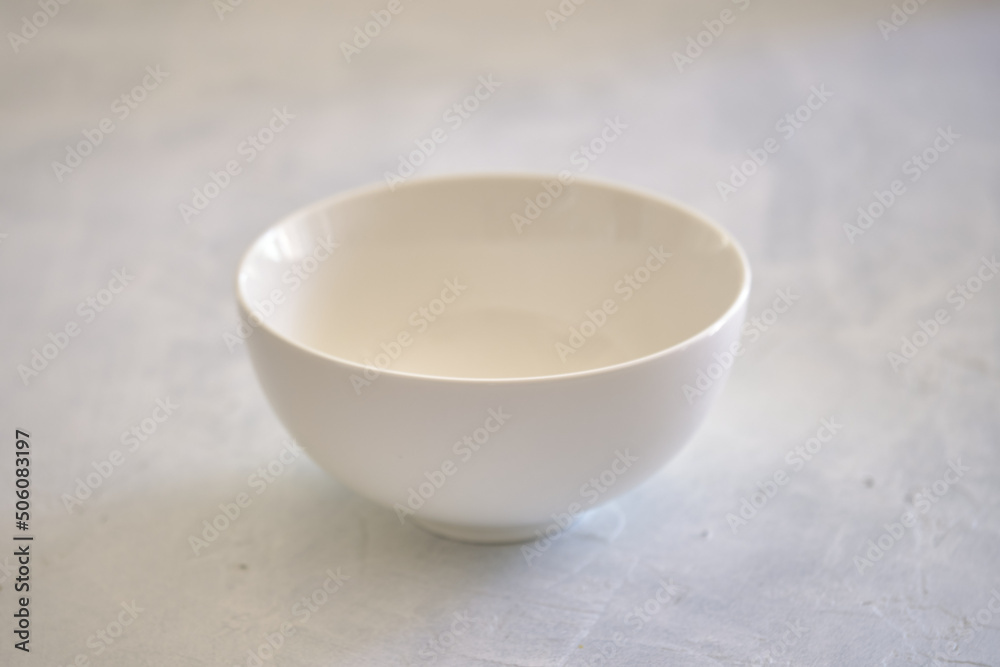 White ceramic plate with a bowl on a concrete table White ceramic plate with a bowl on a concrete table