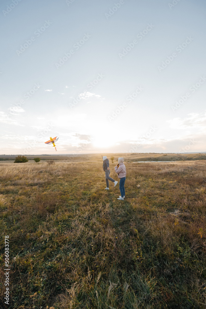 A happy couple flies a kite and spends time together outdoors in a nature reserve. Happy relationships and family vacations. Freedom and space.