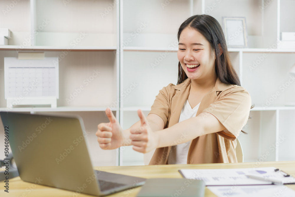 Online lifestyle concept A female staff making a facetime meeting with her co-workers and giving them a compliment by raising her thumbs up. Online lifestyle concept A female staff making a facetime meeting with her co-workers and giving them a compliment by raising her thumbs up.