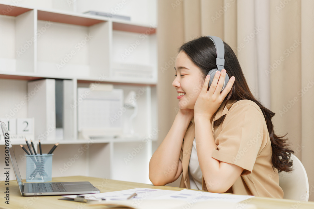 Online lifestyle concept A female staff relaxing herself by listening the music through the headphones. Online lifestyle concept A female staff relaxing herself by listening the music through the headphones.