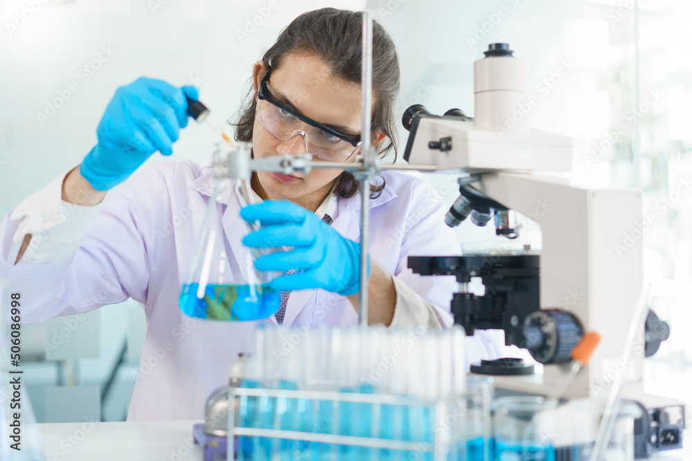 Laboratory research concept, Scientist drop of solution into beaker for research of vaccine Laboratory research concept, Scientist drop of solution into beaker for research of vaccine