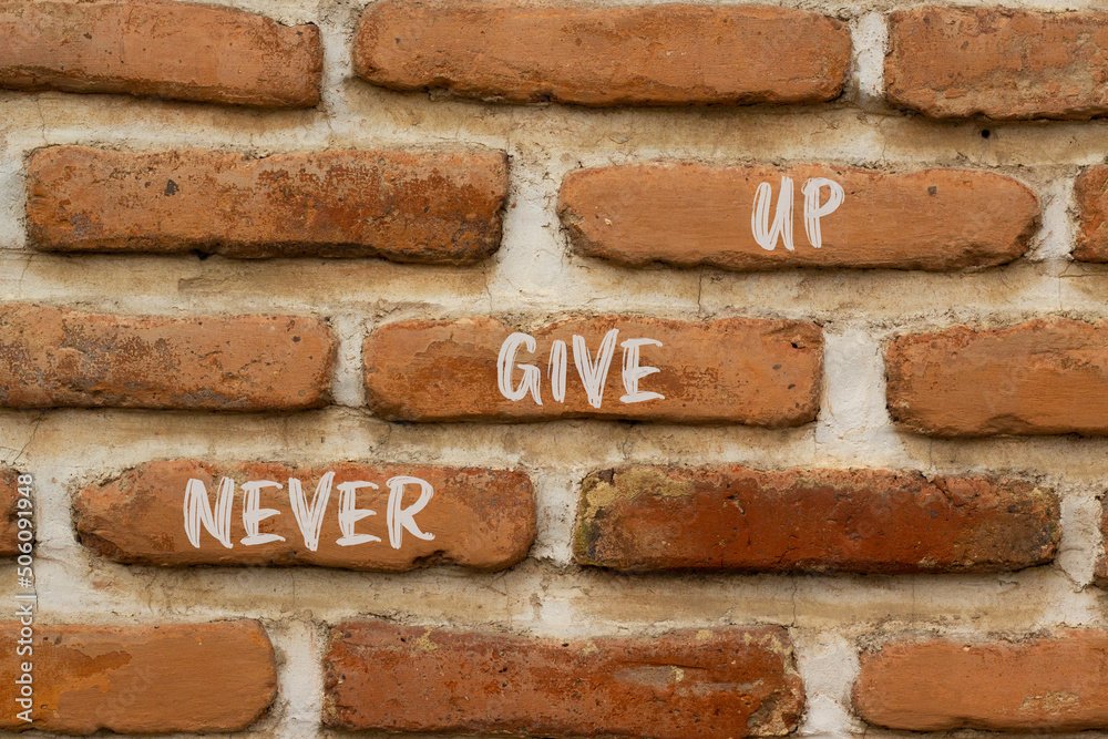 Never give up and support symbol. Concept words Never give up on brick wall. Beautiful brick wall background. Business and never give up quote concept. Copy space. Never give up and support symbol. Concept words Never give up on brick wall. Beautiful brick wall background. Business and never give up quote concept. Copy space.