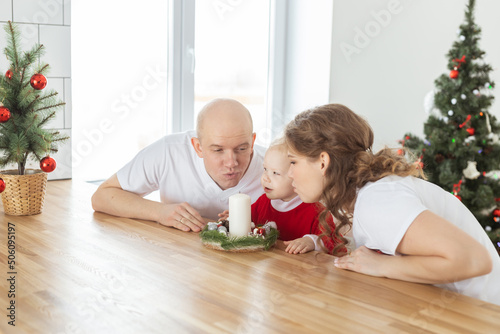 Baby child with hearing aid and cochlear implant having fun with parents in christmas room. Deaf   diversity and health concept