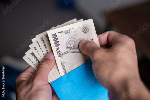 Counting Japanese banknotes by hand from inside a salary envelope