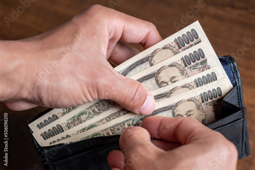 Counting Japanese banknotes by hand from inside the wallet