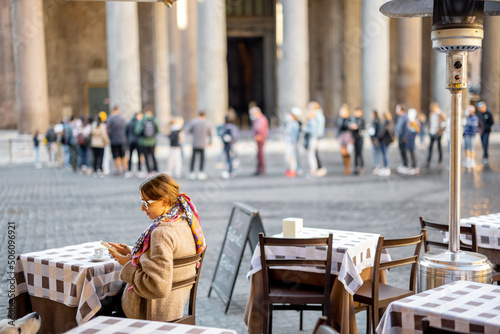 Photography Woman sitting at outdoor cafe near famous Pantheon temple in Rome
