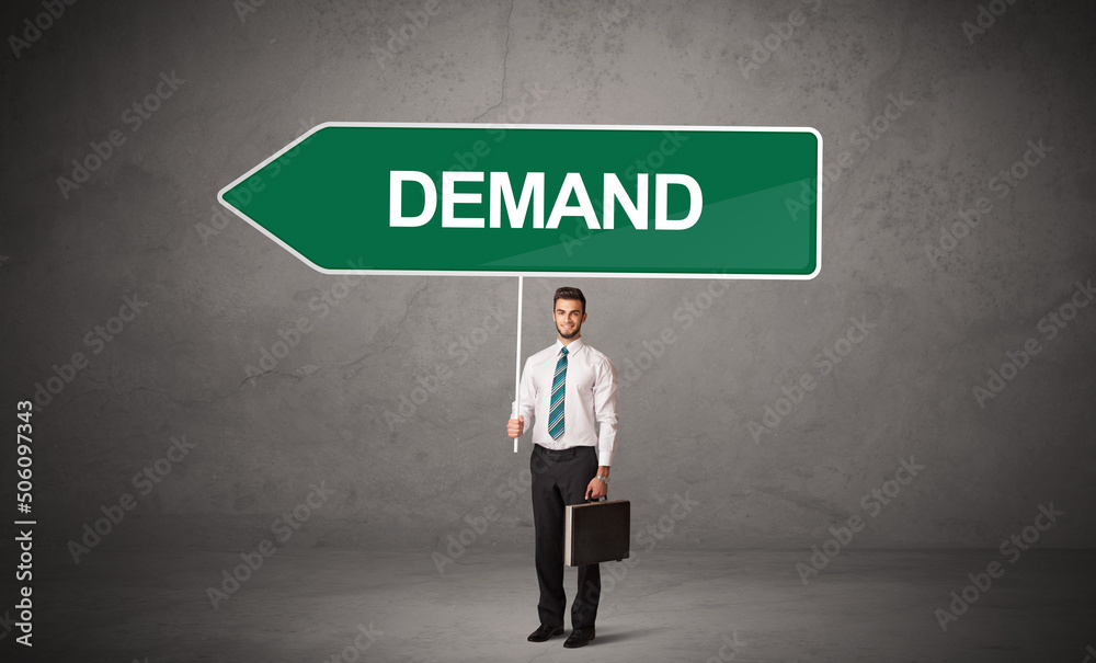 Young business person in casual holding road sign Young business person in casual holding road sign