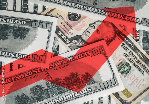 A bright red arrow on the background of money shows the direction up. The concept of changing the exchange rate of the US dollar in the market. Economic growth.