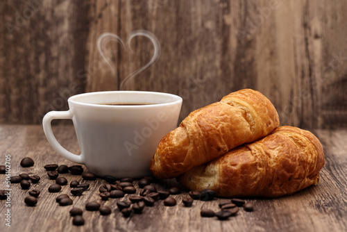 Breakfast is served with smoked coffee in a heart shape. There are coffee beans on the ground.