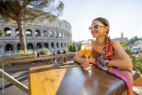 Canvas Print Woman drinking Spritz Aperol at outdoor cafe near Coliseum, the most famous landmark in Rome