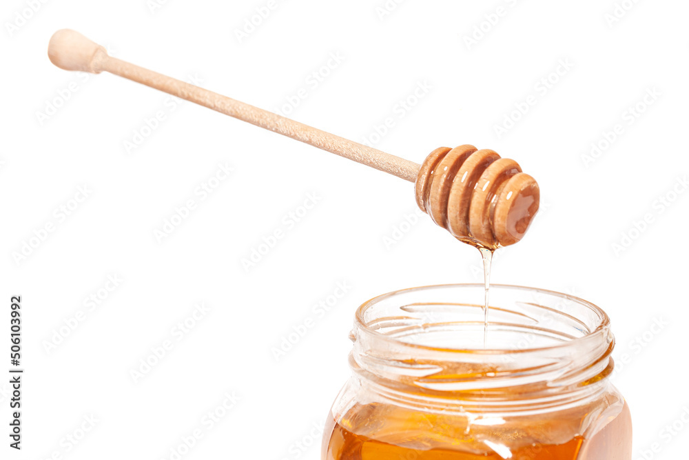Honey dripping from honey dipper in glass jar. Healthy food concept Honey dripping from honey dipper in glass jar. Healthy food concept