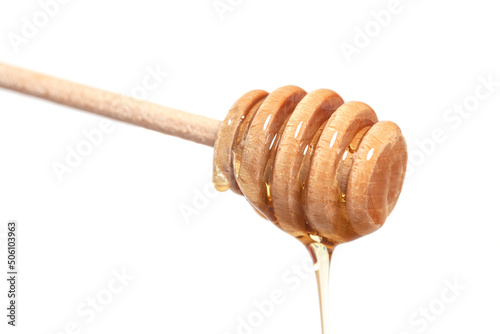 Wooden dipper with honey falling down isolated on a white background. Golden organic floral honey natural.