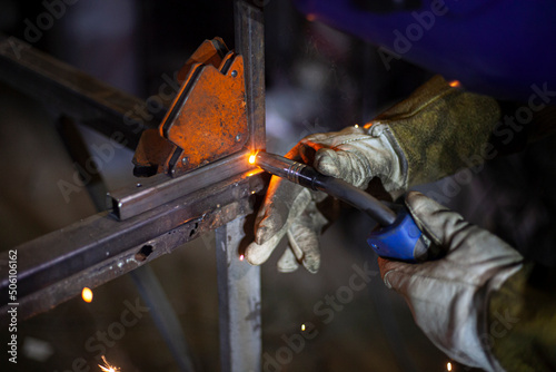 Metal welding. Fire from operation of welding machine. Manufacture of steel seam. Processing of steel profile. Sparks from welding.