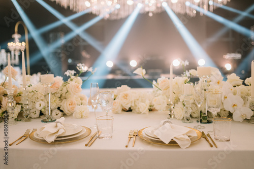 Dinner table rich decorated by candles and flowers. Luxury Wedding decor. Gorgeous concept