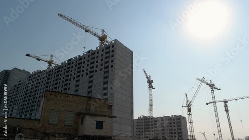 Many cranes and high-rise buildings over blue sky background. Consctrution of skyscrappers. photo