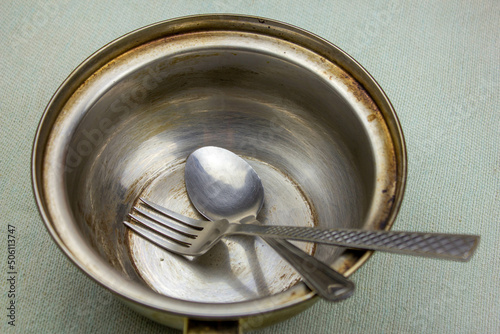 Spoon and fork and empty plate.Plate metal bowl hunger.Hunger concept.