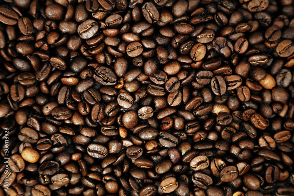 Naklejka premium Close-up of roasted brown coffee beans background 
