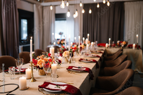 Autumn wedding table setting. Luxury stylish autumn wedding decor. Flowers and tableware on the wedding banquet. Styled romantic dinner in red color
