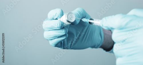 a doctor holding a syringe ready to give a vaccine injection photo
