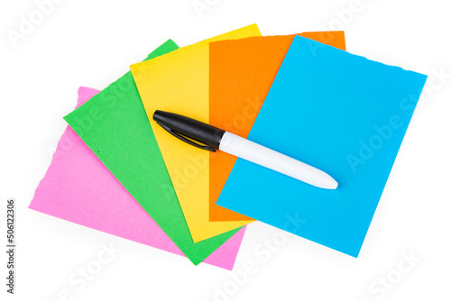 Permanent black marker on multicolored note pad papers isolated over white. Top down view