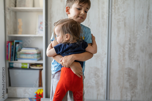 Wallpaper Mural Brother and sister small caucasian boy and girl children toddler and preschooler holding his sister while standing alone at home in bright room in day childhood growing up family concept copy space Torontodigital.ca