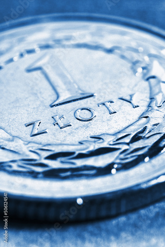 Translation: 1 zloty. Fragment of Polish one zloty coin closeup. National currency of Poland. Blue tinted vertical illustration for news about banking or finance. Macro