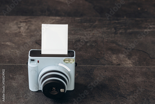 Vintage photo camera on dark background with photo cards. Polaroid camera
