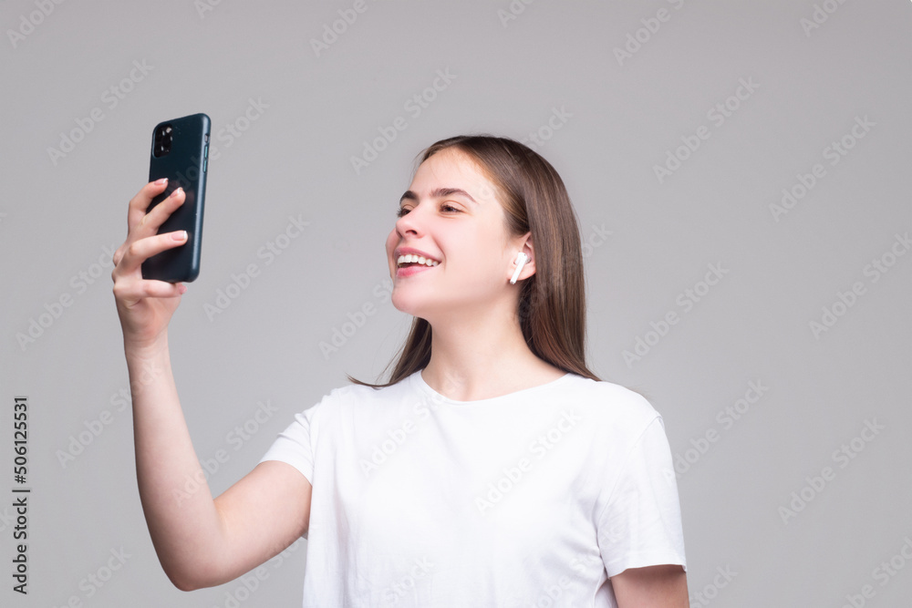 Girl making taking selfie. Young woman over isolated gray background with phone. Girl making taking selfie. Young woman over isolated gray background with phone.