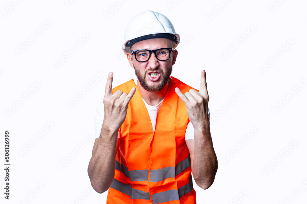 Young male construction worker showing rocker goat sign on light background. Young male construction worker showing rocker goat sign on light background.