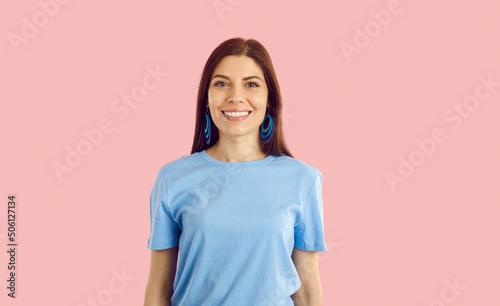Headshot portrait of smiling young woman in casualwear isolated on pink studio background. Happy millennial girl show healthy even teeth after oral care or dental appointment. © Studio Romantic