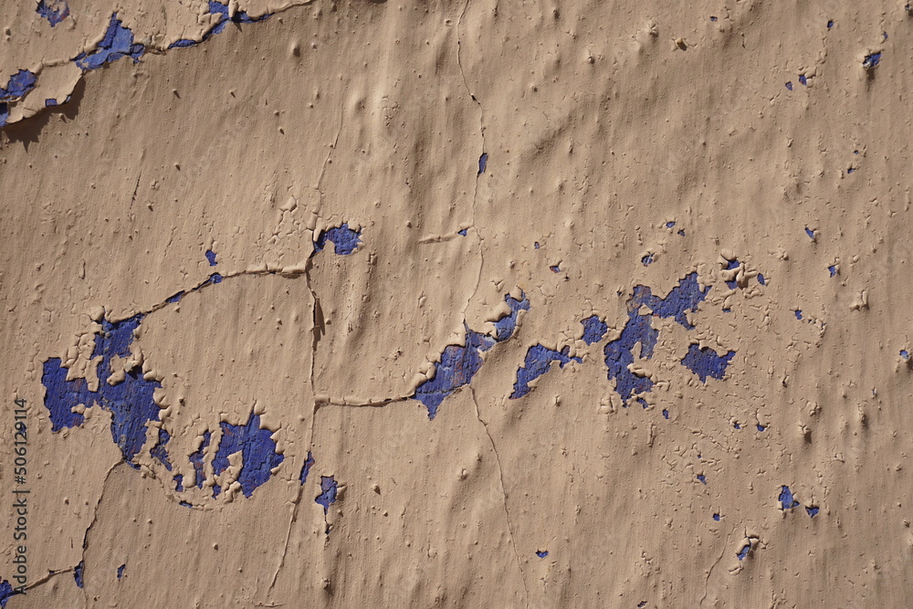 cracked plaster wall detail showing layers of blue underneath