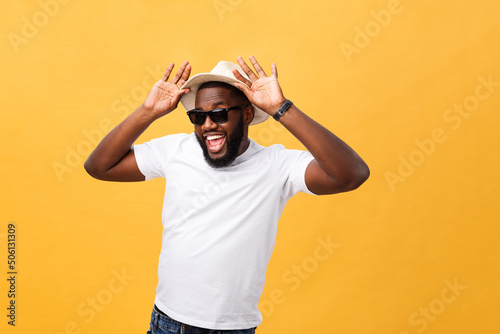 Canvas Print Close up portrait of a young man laughing with hands holding hat isolate over ye