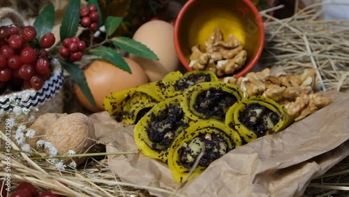 Pancakes, traditional Ukrainian slapjack with poppy seeds and walnuts. In red wooden utensils with Petrikovskaya painting. Craft eco paper. Maslenitsa, fried flapjack	