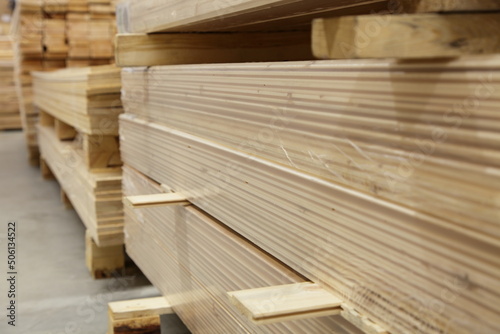 Planed wooden boards stack storage in perspective. Carpentry plant stock