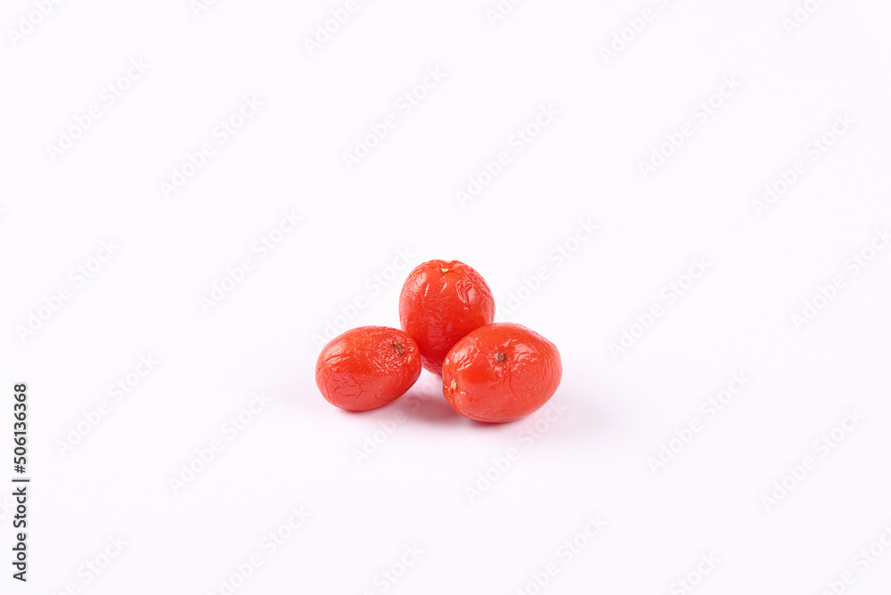 Not fresh shrivelled tomatoes on white background.