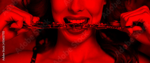 Sexy woman in red light bite handcuffs photo