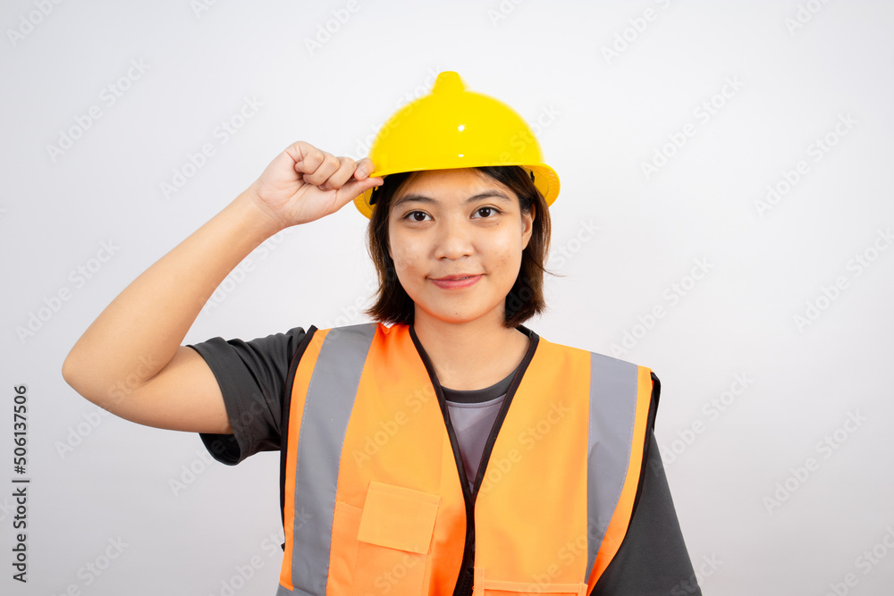An Asian woman engineer in a working uniform is smiling and looking at the camera with determination isolated on white background. An Asian woman engineer in a working uniform is smiling and looking at the camera with determination isolated on white background.