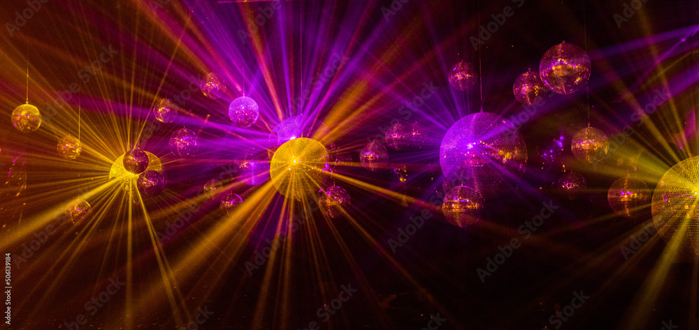 Naklejka premium abstract background with lights mirror disco balls in the light of multi-colored rays.