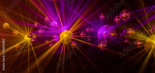 abstract background with lights mirror disco balls in the light of multi-colored rays.