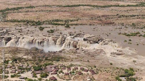 Aerial view of Augrabies Falls in flood. Pull back to reveal vast arid landscape around