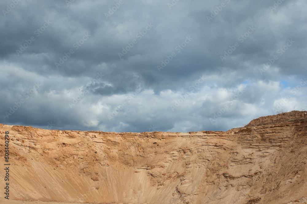 a sand quarry, in the photo a sand quarry and a gray sky in the background a sand quarry, in the photo a sand quarry and a gray sky in the background