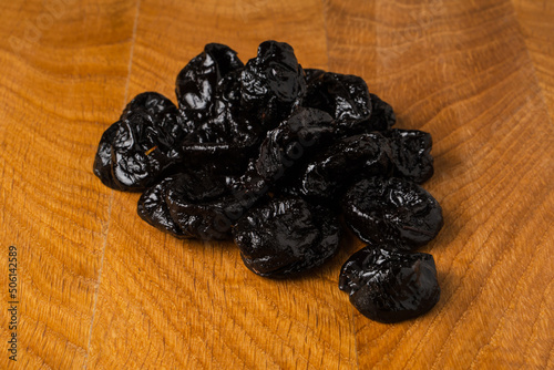 Dried dried prunes in a heap on a wooden board